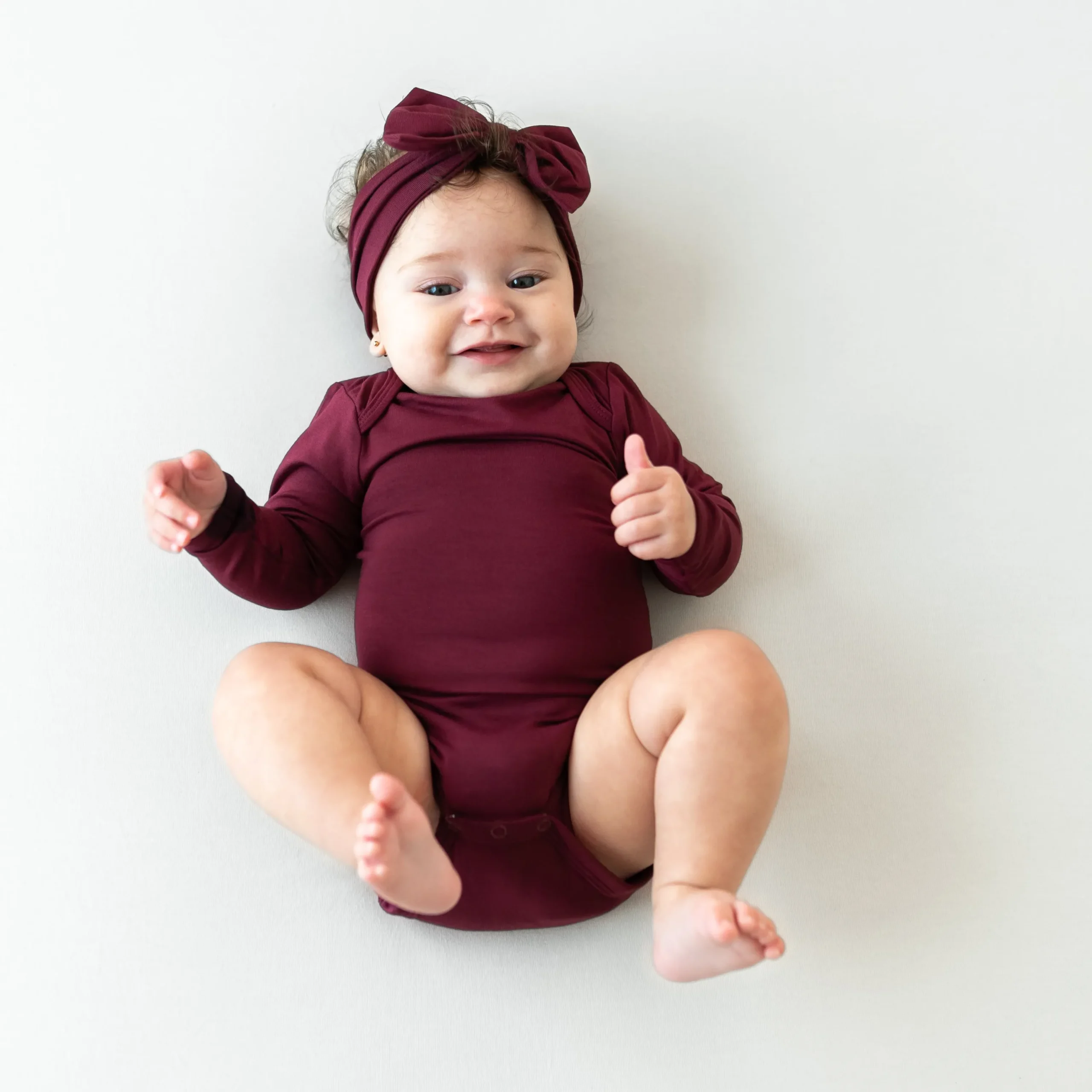 Kyte Baby Long Sleeve Bodysuit in Burgundy Hot